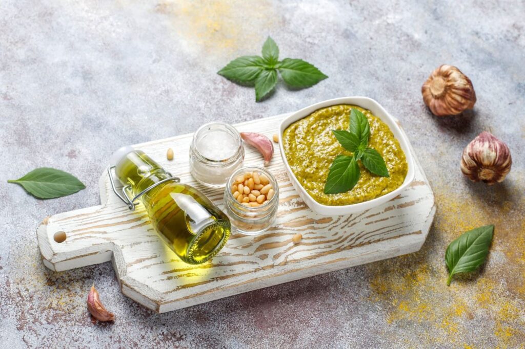 Italian basil pesto sauce with culinary ingredients for cooking