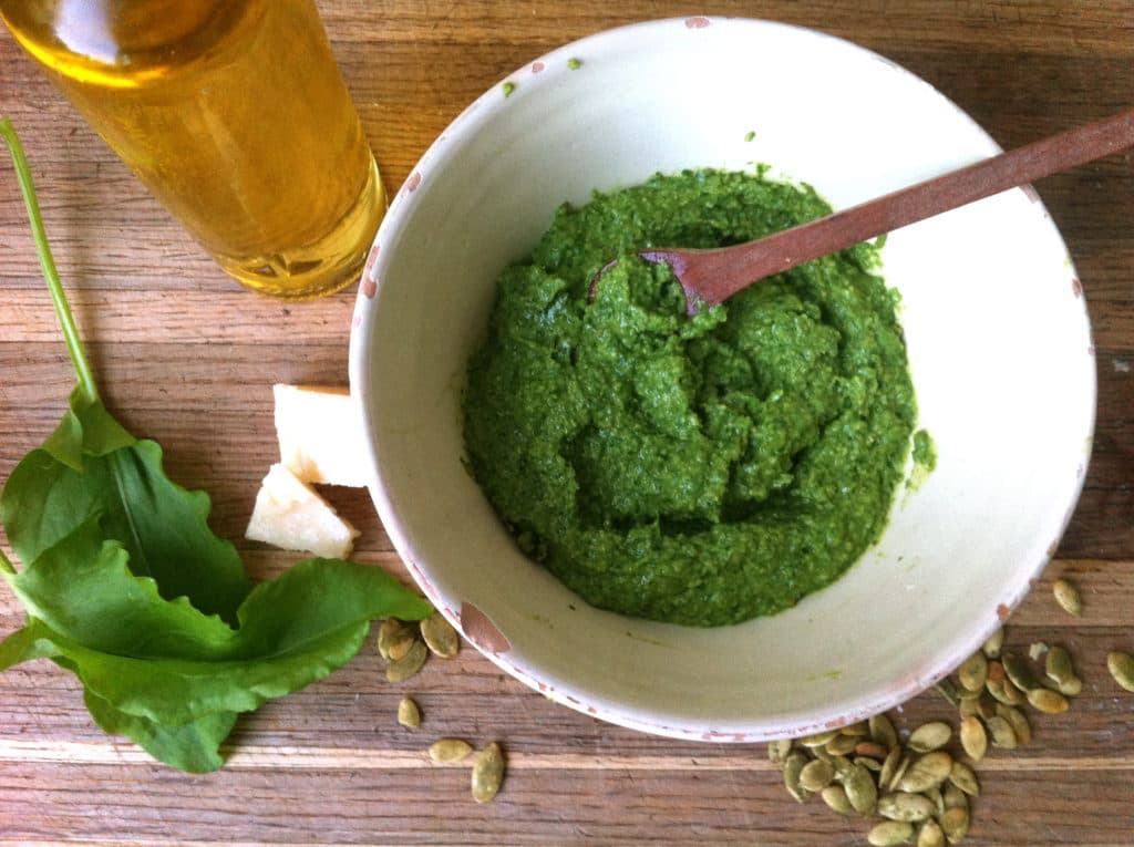 Shredded pesto sauce in a bowl with a wooden spoon