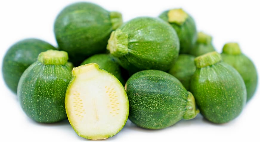 Lots of little green pumpkins lying in a pile